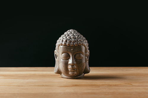 Sculpture of buddha head on wooden tabletop