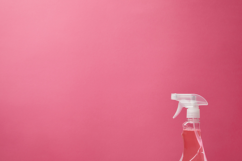 spray bottle with antiseptic liquid isolated on pink