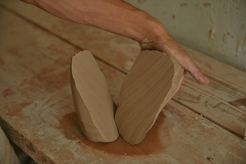 cropped image of professional potter working with clay at workshop