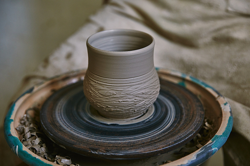 selective focus of clay pot on pottery wheel at workshop
