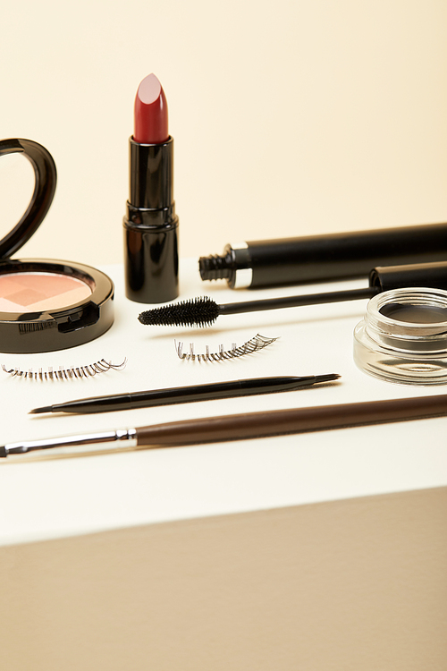 close-up shot of various makeup accessories on beige