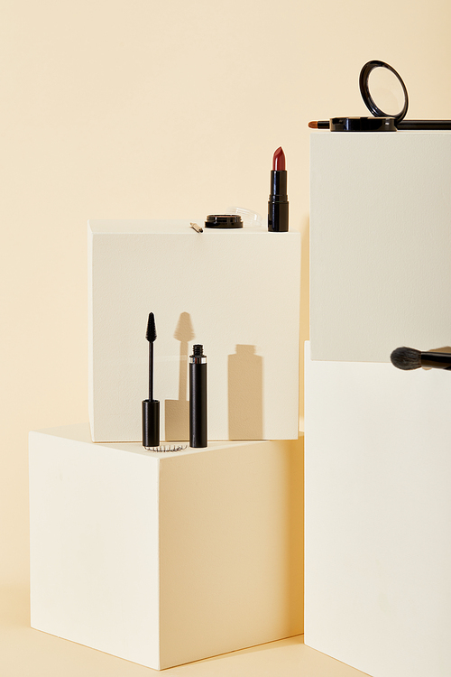 various makeup supplies lying on beige cubes