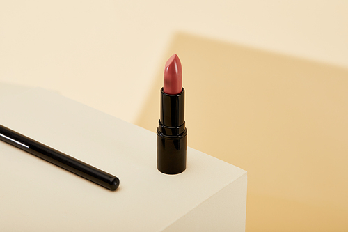 close-up shot of lipstick standing on beige surface
