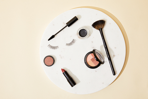 top view of various cosmetics lying on round plate