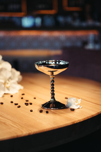 selective focus of alcoholic cocktail in metal glass on wooden table with dark background