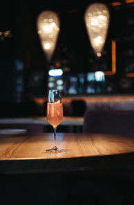 selective focus of pink alcoholic cocktail on dark background with copy space