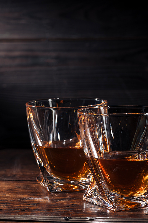 close-up view of two glasses of whisky on dark wooden table