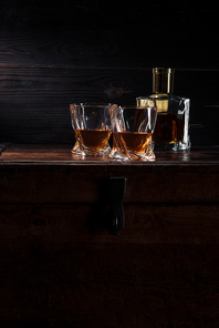 bottle and glasses of whiskey on vintage wooden table
