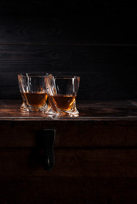 two glasses of whiskey on vintage wooden table