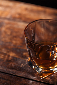 close-up view of glass of luxury whiskey on wooden table