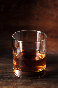 close-up view of glass of luxury amber alcohol on wooden table