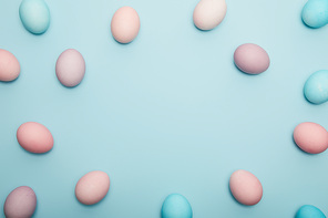 Top view of easter eggs on blue background with copy space