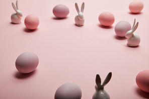 toy bunnies and chicken easter eggs on pink background with copy space