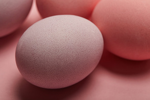 Selective focus of painted easter eggs on pink background