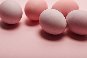 painted easter eggs on pink background with copy space