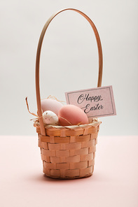 painted easter chicken and quail egg in straw basket, card with happy easter lettering