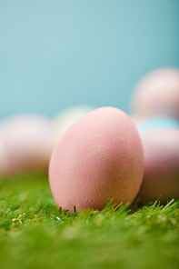 selective focus of easter painted eggs on grass with copy space