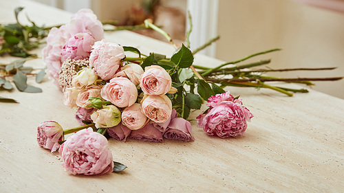 bouquet with roses and peonies on table at flower shop