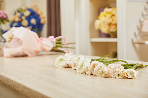 selective focus of white peonies on surface