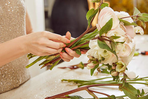 cropped view of florist making bouquet of white peonies at workspace
