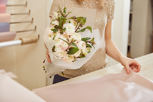 partial view of florist holding bouquet of white peonies