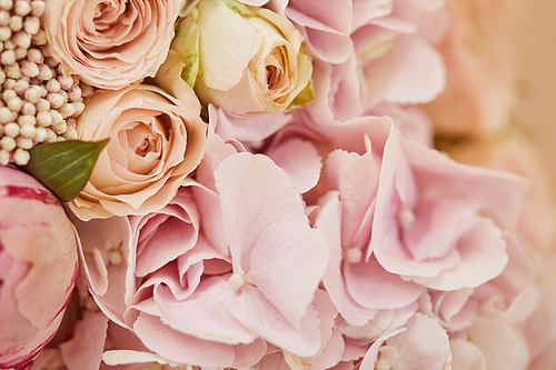 close up of bouquet of roses and pink peonies on table