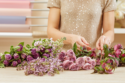 cropped view of florist making bouquet of tulips, peonies and lilac