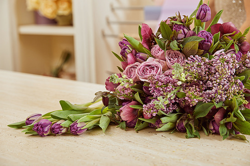 selective focus of purple tulips, peonies and lilac on surface