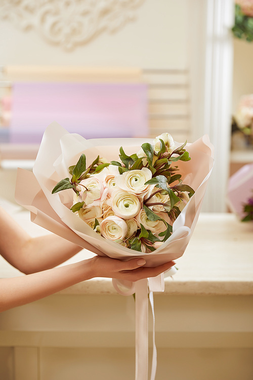 partial view of florist holding bouquet of white peonies