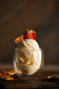 selective focus of delicious ice cream with piece of waffle and strawberry in glass