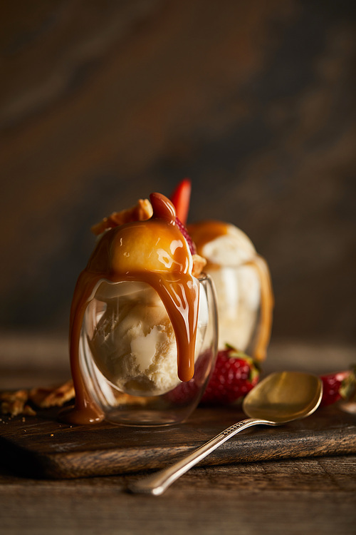 delicious ice cream with caramel in glass on chopping board