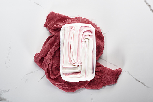 top view of delicious ice cream on pink cloth on marble grey background