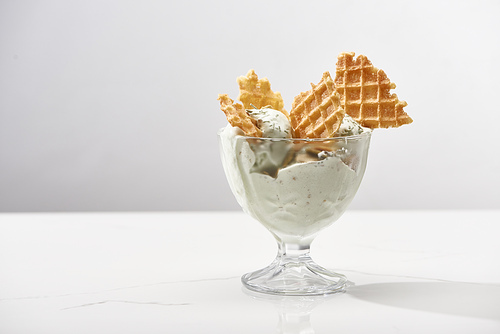 delicious pistachio ice cream with waffles isolated on grey
