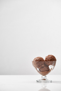 delicious chocolate ice cream in glass bowl isolated on grey with copy space