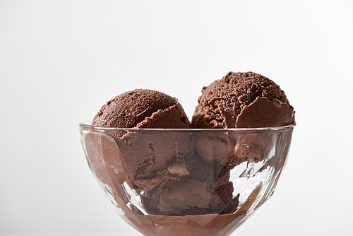 close up view of fresh delicious chocolate ice cream in glass bowl isolated on grey