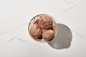 top view of delicious chocolate ice cream in bowl on marble grey background