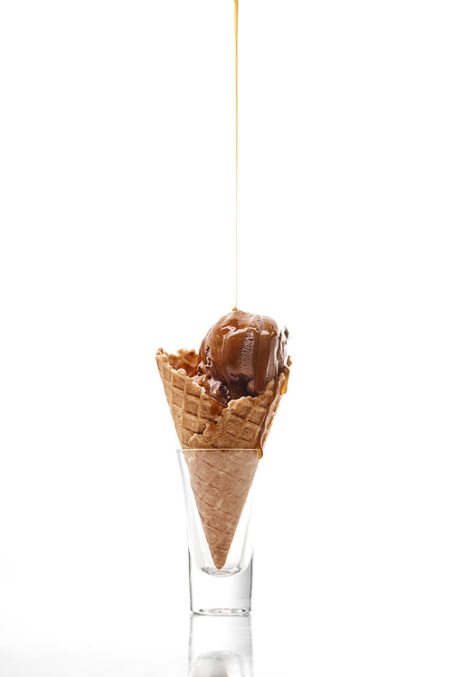 delicious sweet ice cream in crispy waffle cone with dripping chocolate isolated on white