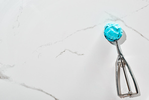 top view of delicious blue ice cream in ice cream spoon on marble grey background