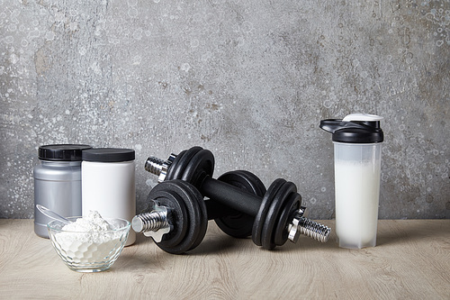 protein shake in sports bottle near jars near concrete wall