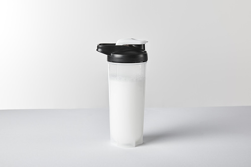 sports bottle with protein shake on white