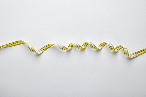 top view of yellow measuring tape on white