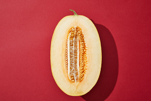 top view of halved fresh ripe tasty melon on red background