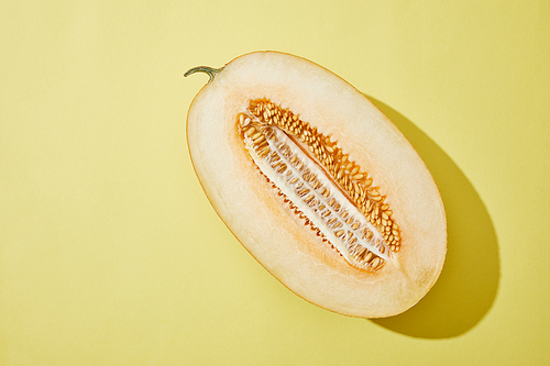 top view of fresh ripe halved melon on yellow background