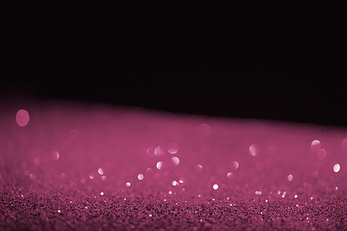 blurred purple glowing glitter on black background