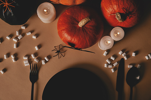 top view of pumpkins| black plate| fork and knife with marshmallows on table| halloween concept
