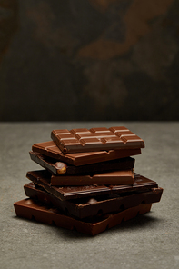 close-up view of sweet assorted stacked chocolate bars on grey