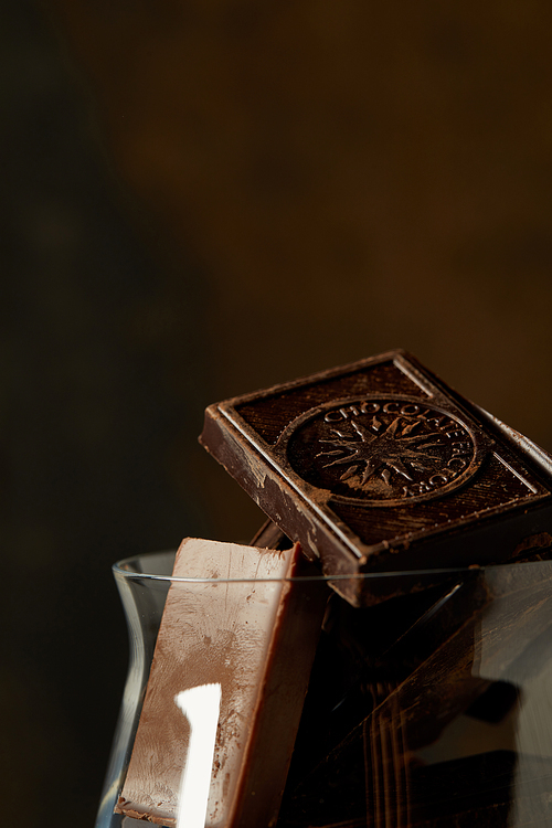 close-up view of gourmet chocolate pieces in glass on dark background