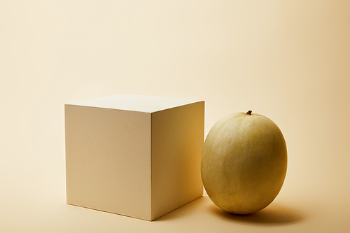 close-up shot of ripe melon and cube on beige surface