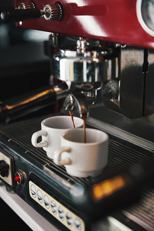 close-up view of coffee machine and two mugs with espresso