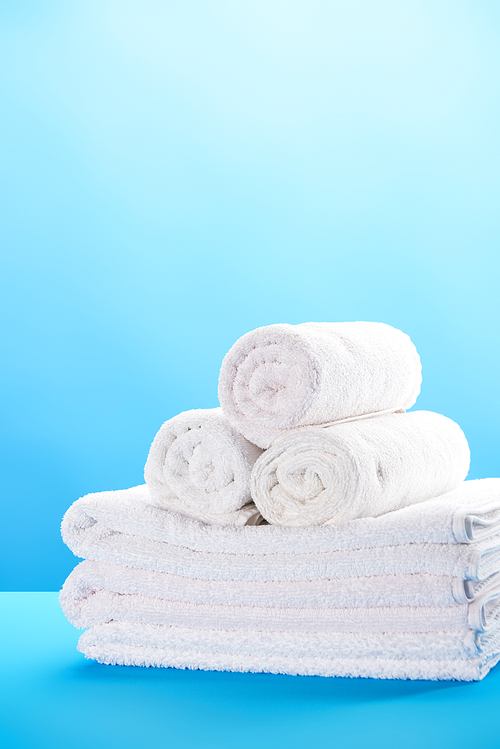 close-up view of rolled and stacked clean white towels on blue